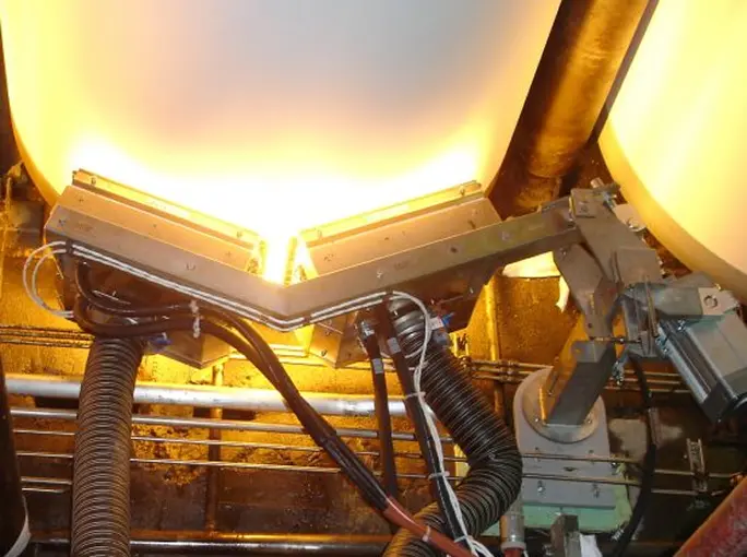 Close-up of angled infrared emitters drying a continuous sheet in a manufacturing process.